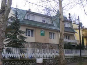 a house with a white fence in front of it at Prima Pihenő in Miskolctapolca
