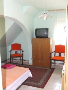 - un salon avec deux chaises et une télévision dans l'établissement Prima Pihenő, à Miskolctapolca