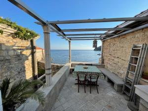 a patio with a table and chairs and a lighthouse at Budva Old Town Beach House in Budva