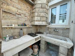 a stone kitchen with a sink and a window at Budva Old Town Beach House in Budva