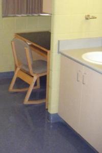 a bathroom with a desk with a chair and a sink at Hotel Laurier - King Street Residence in Waterloo