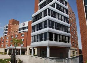 a tall building in front of a brick building at Hotel Laurier - King Street Residence in Waterloo