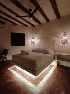 a room with a bed, a lamp, and a window at Casa Mech in Holbox Island