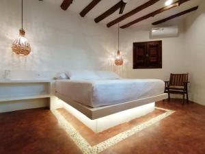 a bedroom with a bed and two pendant lights at Casa Mech in Holbox Island