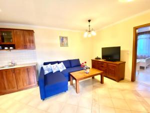 uma sala de estar com um sofá azul e uma mesa em Santa Marina 2-bedroom apt. w/ Sea View + Terrace em Sozopol