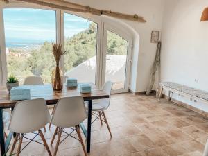 a dining room with a table and chairs and a large window at Montgo Home in Jávea
