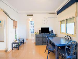 een eetkamer met een tafel en een tv bij Apartment with pool in Urb Medina del Sol in Denia
