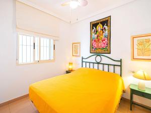 een slaapkamer met een geel bed en een raam bij Apartment with pool in Urb Medina del Sol in Denia