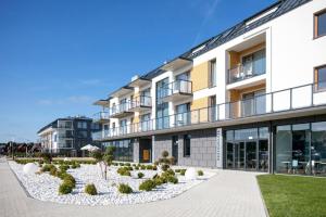 ein Apartmenthaus mit einem Garten davor in der Unterkunft Apartments Deluxe SARBINOWO in Sarbinowo