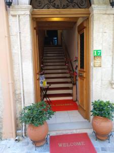 a stairway with two potted plants in front of a door at Santrivani Rooms in Chania