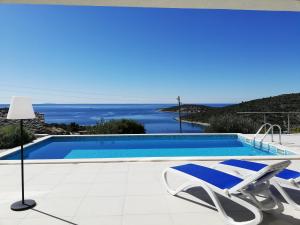 a villa with a swimming pool and a chair at Captain's Villa Seadream in Sevid