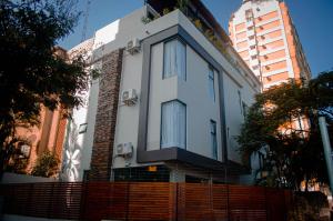 a white house with a fence in a city at Terra Guest House in Maputo