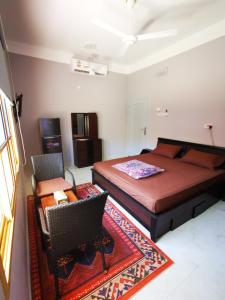 a bedroom with a bed and a chair and a table at Al Hamra Guest House in Al Ḩamrāʼ