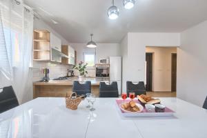 a white kitchen with a table with a tray of bread at Villa Stella in Labin