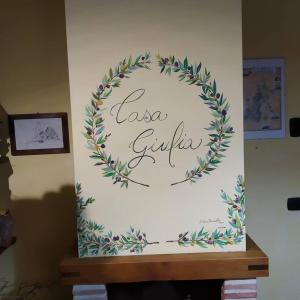 um sinal numa parede com uma coroa de flores em Casa Giulia on Francigena em Gambassi Terme