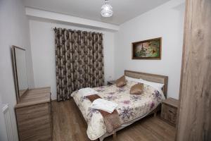 - une petite chambre avec un lit et un rideau dans l'établissement Korca Apartments, à Korçë