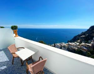 a balcony with a table and chairs and the ocean at Palazzo Marzoli charme Resort - Small Luxury Hotel in Positano