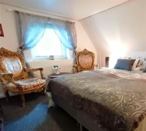 ein Schlafzimmer mit 2 Stühlen, einem Bett und einem Fenster in der Unterkunft Bed & Healing 