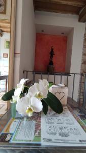 un vaso di fiori su un tavolo con una statua di Le rondini di San Donato a Lucca