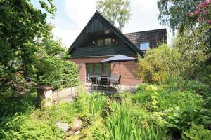 a house with a patio and an umbrella at WEIßE HÖHEN -Ferienhaus, Dibbersen bei Hamburg in Buchholz in der Nordheide