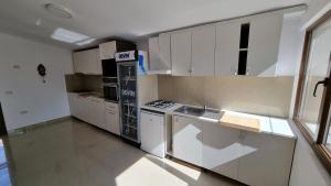 a kitchen with white cabinets and a stove top oven at Casa Amy in Eforie Nord