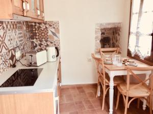 una cucina con tavolo e tavolino con sedie di CHIOS MANTALENAS Apartments a Véssa