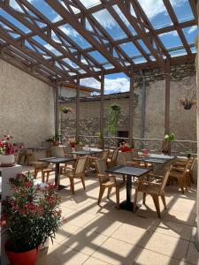 a patio with tables and chairs under a glass roof at Auberge La Cascade in Avrieux