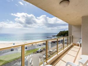 a balcony with a view of the beach and the ocean at Ebbtide 22 in Forster