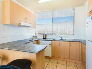 a kitchen with wooden cabinets and a sink at Ebbtide 6 in Forster
