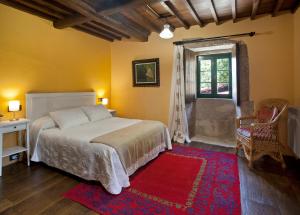 a bedroom with a bed and a window and a red rug at Casa Vistaboa Ribeira Sacra in Chantada