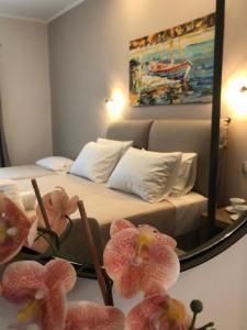 1 dormitorio con 1 cama con espejo y flores rosas en Dokos Studios, en Parga