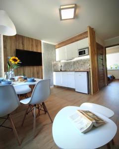 ウェバにあるLAGO Apartamenty i pokojeのキッチン(テーブル、椅子付)