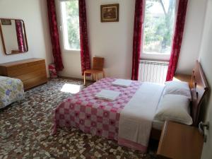 a bedroom with a bed and two windows at Venice View Guesthouse in Marghera