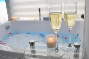 two glasses of wine and a candle in a bath tub at Blue Horizon Luxury Apartment in Nerja