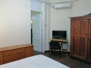 1 dormitorio con 1 cama y escritorio con ordenador en Apartamento en Edificio Palacio Colón, en Montevideo