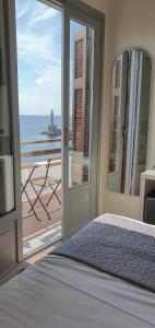 a bedroom with a bed and a view of the ocean at Amphitrite Hotel in Chania Town