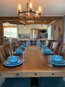 a large wooden table with blue bowls and glasses on it at Downeast Coastal Maine Escape! in Milbridge