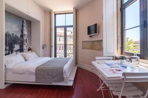 una camera d'albergo con letto, scrivania e finestre di Oporto Near Center a Porto