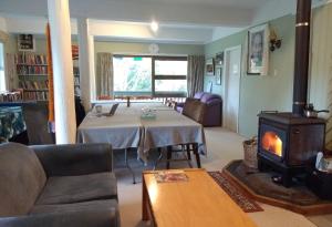 een woonkamer met een tafel en een houtkachel bij Mahamudra Buddhist Centre in Colville