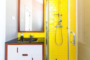 ein Badezimmer mit Waschbecken und Dusche mit gelben Fliesen in der Unterkunft ON Apartments - Center in Porto + 27 Fotos