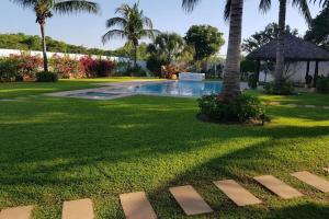 a yard with a swimming pool and palm trees at Casa en Acapulco Diamante in Acapulco