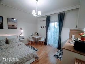 1 dormitorio con cama, mesa y ventana en Elegant Central Studio Free wifi and netflix en Volos