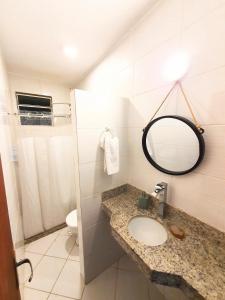 a bathroom with a sink and a mirror and a toilet at Solar das Rosas in Salvador