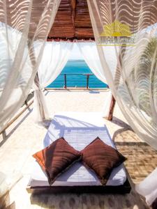 a bed in a tent with a view of the ocean at SUN7 in Morro de São Paulo