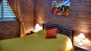 AlbardónCASA Zona Huarpe Hospedaje的一间卧室配有一张带两盏灯的绿床。