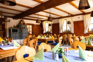 a dining room with tables and chairs and lights at Zur frischen Quelle in Oberasbach