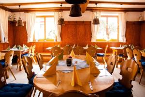 a dining room with tables and chairs and windows at Zur frischen Quelle in Oberasbach