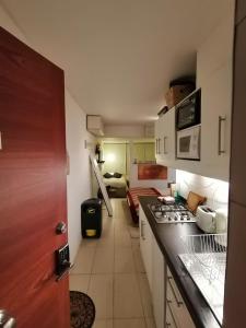 a kitchen with a stove and a living room at SKI In/Out Monteblanco El Colorado in Santiago