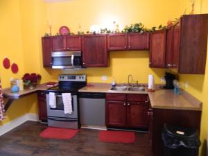 uma cozinha com armários de madeira, um fogão e um lavatório em Marie@305 em Savannah