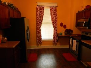 a kitchen with a window with red and white curtains at Marie@305 in Savannah